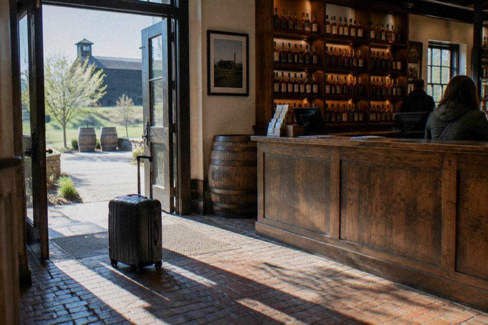 A visitor center desk with wooden shelves of bourbon bottles behind it
