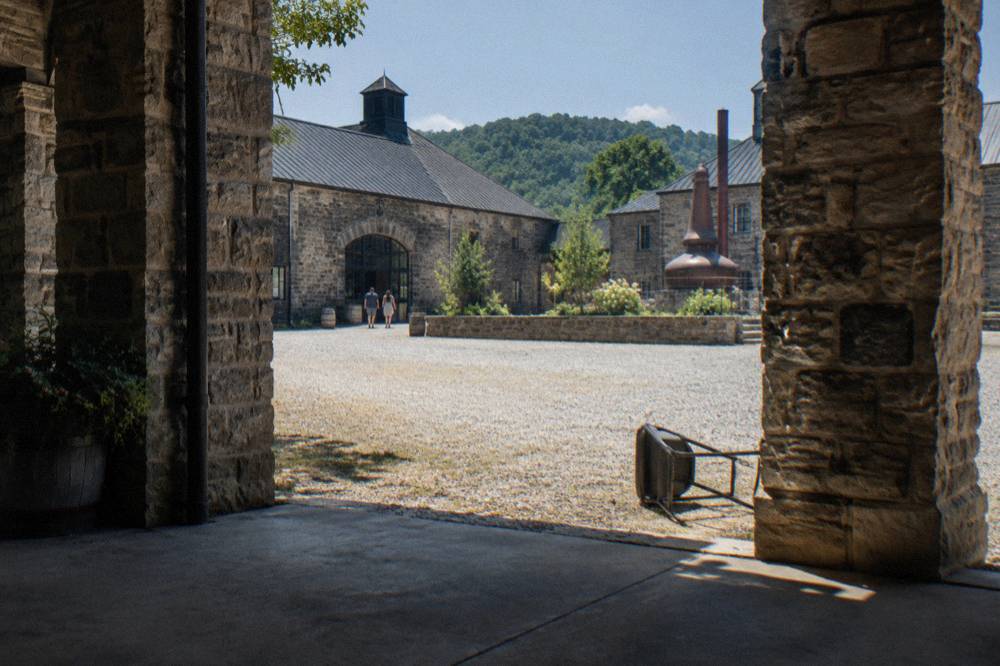A historic limestone distillery building with brick warehouses on the Buffalo Trace campus in Frankfort