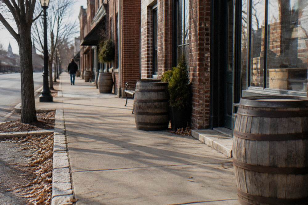 Small town street in Bardstown Kentucky with storefronts and barrels out front