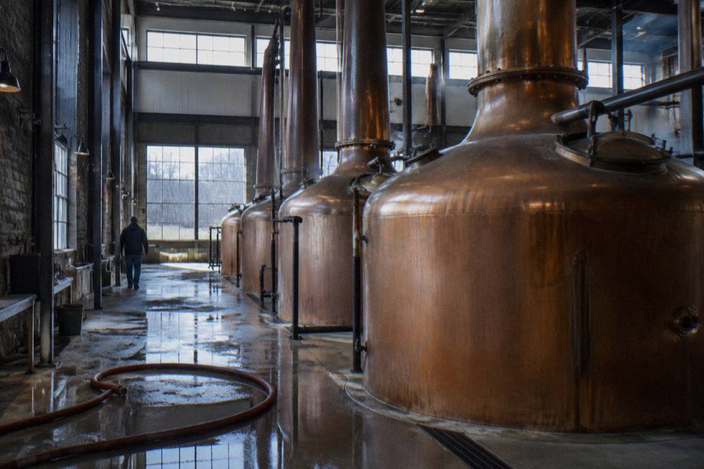 Copper fermentation tanks inside a bourbon distillery production hall