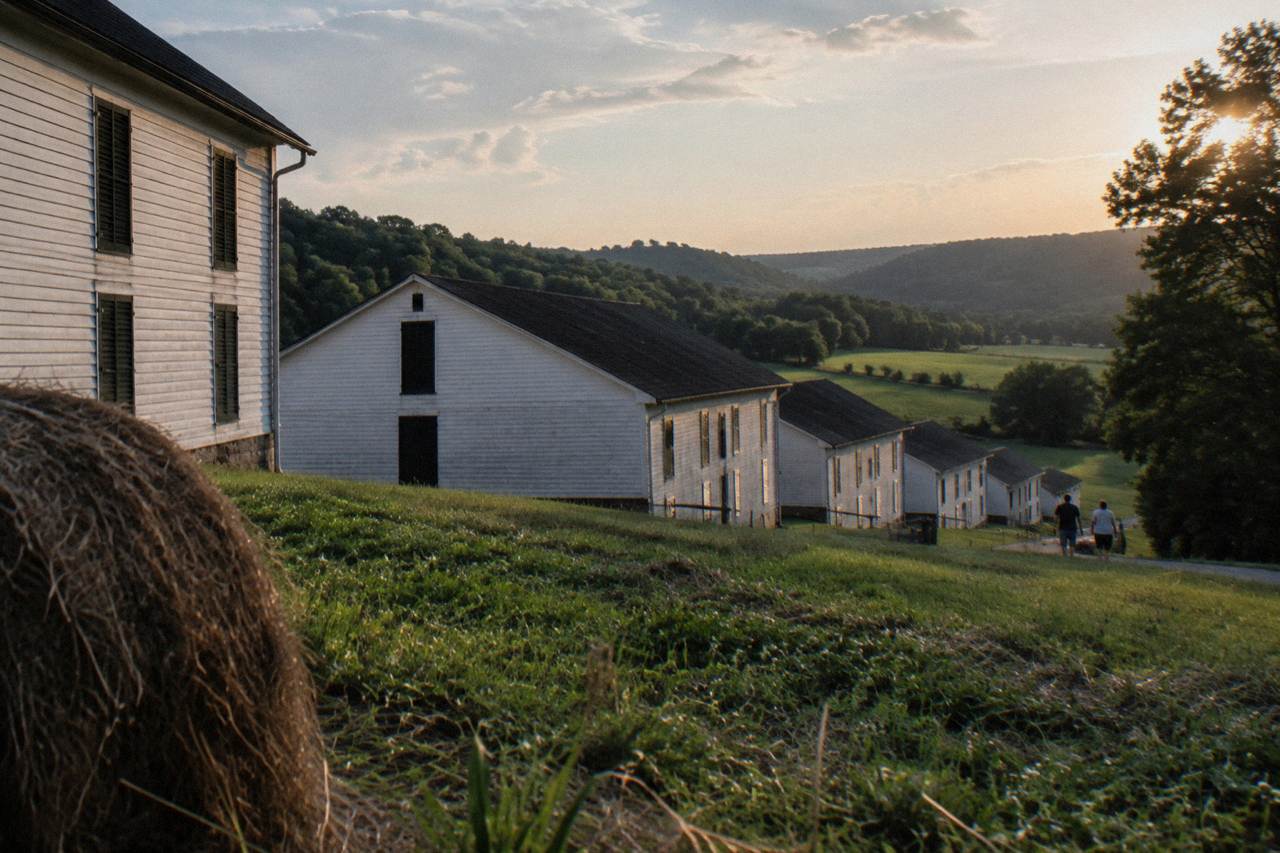 Wooden rackhouse buildings and rolling green hills at a Kentucky bourbon distillery campus