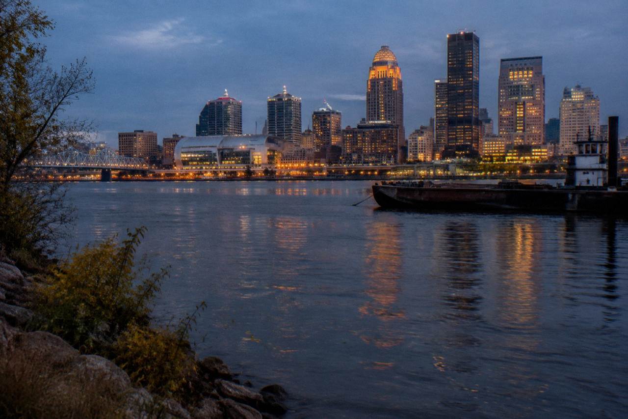 Downtown Louisville skyline at dusk with the Ohio River in the foreground