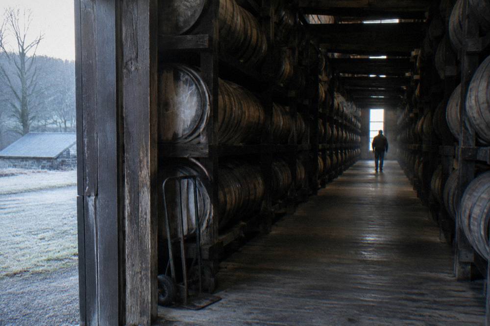 Barrel rickhouse interior with stacked aging bourbon barrels