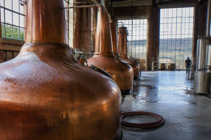 Copper pot stills inside a bourbon distillery production hall