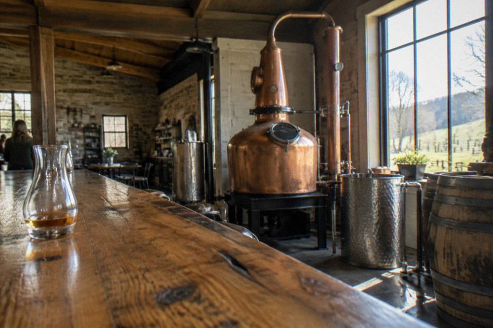Small copper pot still inside a craft distillery tasting room