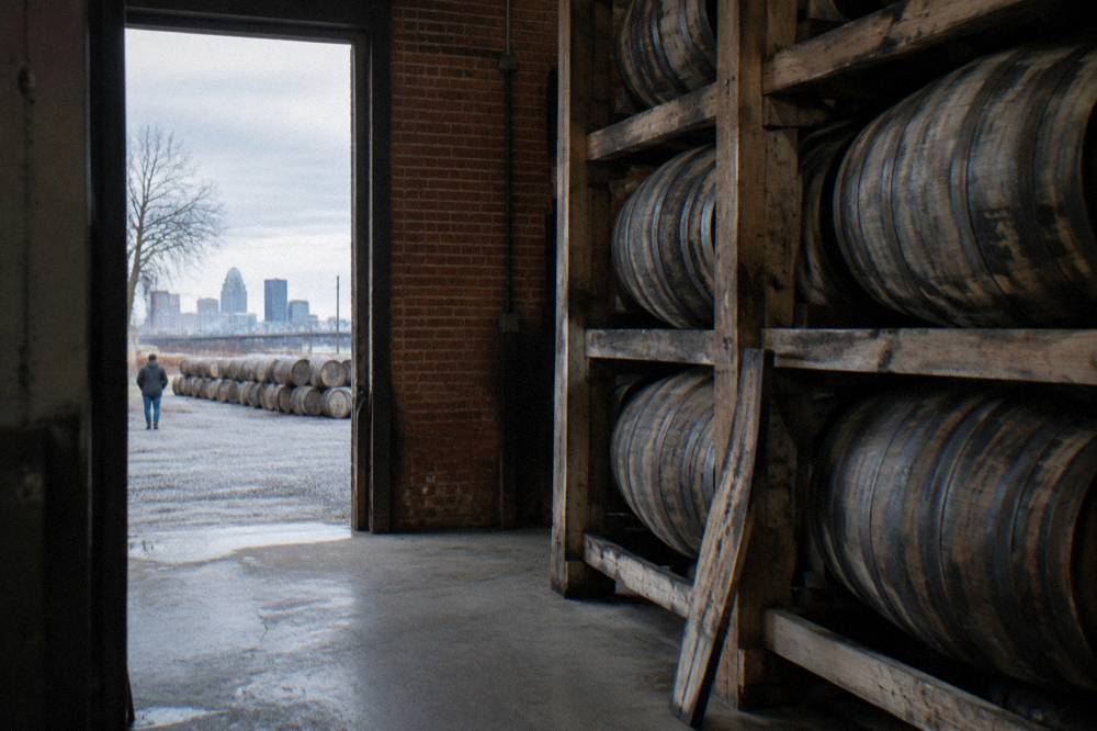 Bourbon barrels stacked inside a Louisville distillery aging warehouse