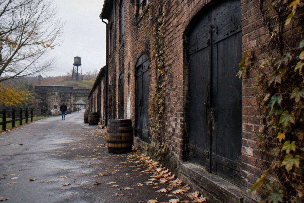 Weathered brick warehouse with black iron doors on a Kentucky distillery campus