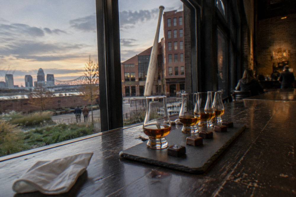 Bourbon pours and chocolate pairings arranged on a dark wooden tasting bar