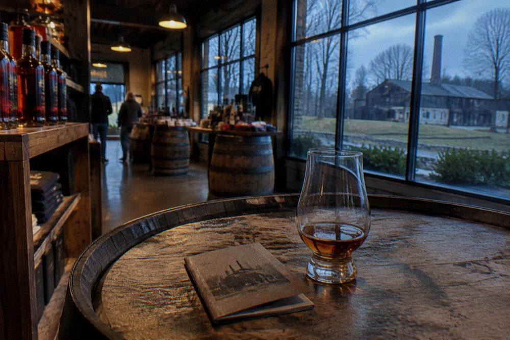 A retired passport booklet resting on a bourbon barrel head inside a distillery gift shop