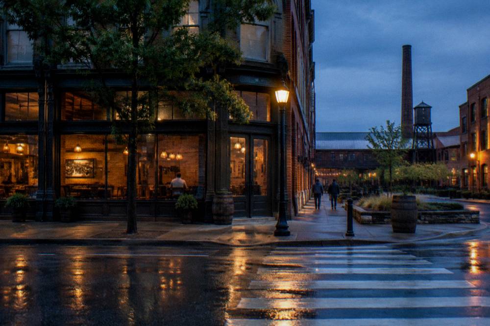 A streetscape of downtown Louisville with a pedestrian crosswalk and evening light