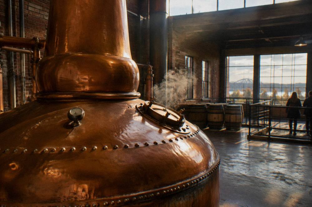 A copper pot still glowing inside a working Kentucky distillery stillhouse