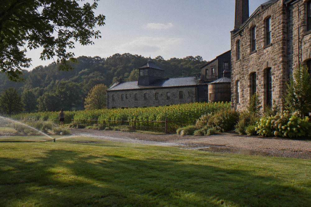 Stone distillery building with limestone walls and green lawn in horse country