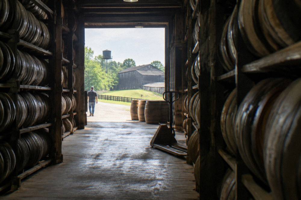 Barrel warehouse aisles stacked with aging oak bourbon barrels